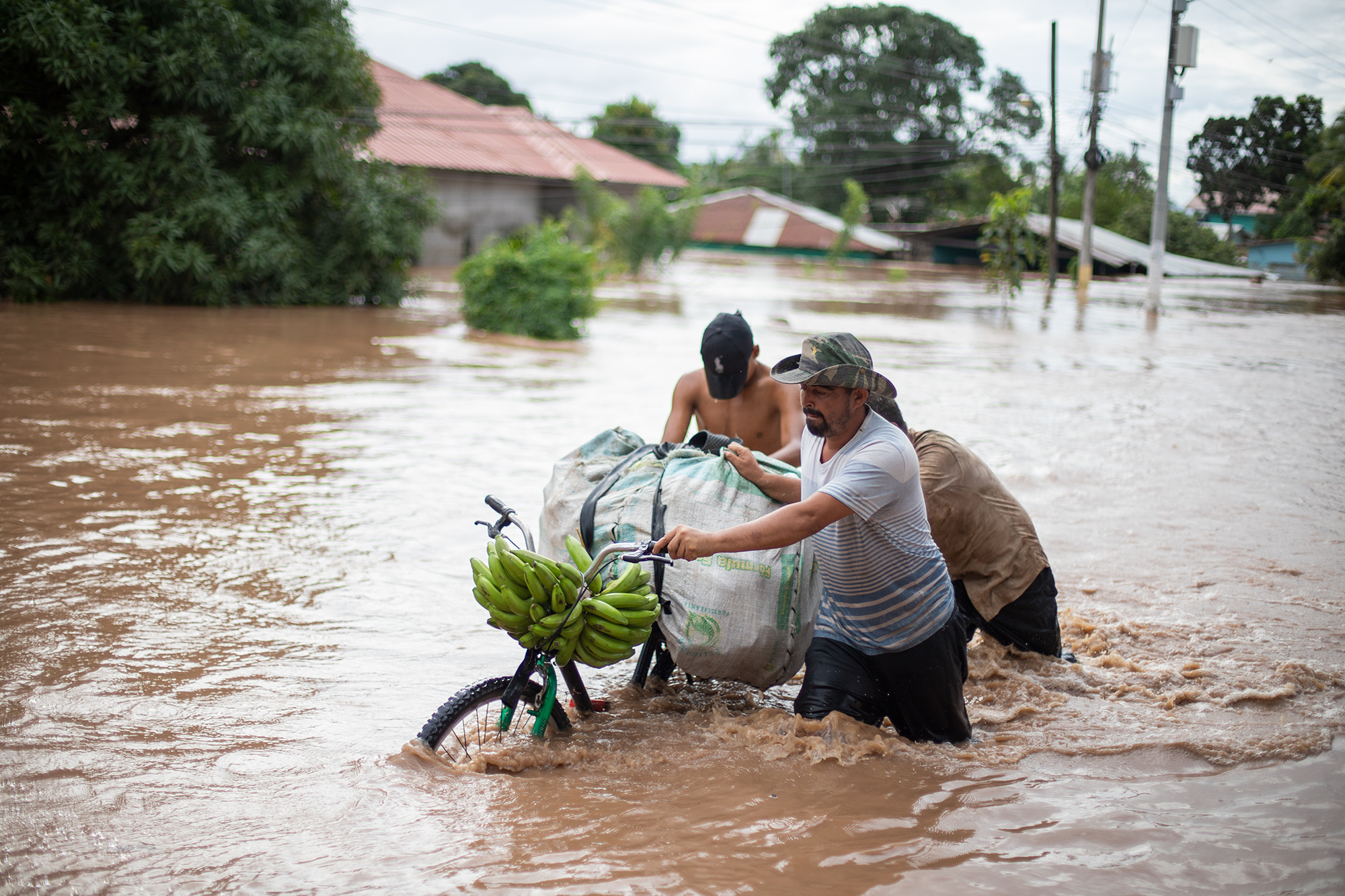 Un grupo de trabajadores de la compañía frutera Dole ha caminado en medio de la inundación a unos 800 metros desde la empacadora de la bananera en Omonita. San Manuel, Cortés, 18 de noviembre de 2020. Foto: Martín Cálix.