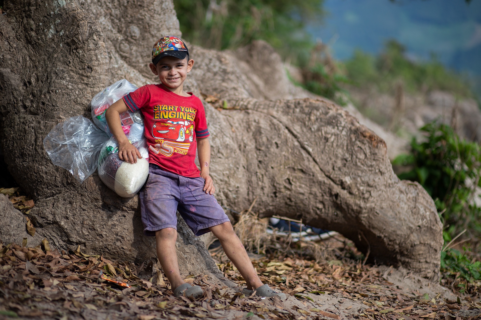 Ángel, de 9 años, debe cargar desde la orilla del río Ulúa hasta su casa, la ayuda alimenticia que el Movimiento Ambientalista Santabarbarense ha gestionado para su comunidad. Santa Bárbara, 25 de enero de 2021. Foto: Martín Cálix.