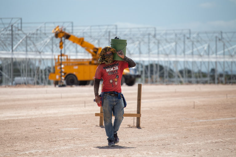 Un obrero carga un balde con herramientas durante los trabajos de construcción de la Zede Orquídea. San Marcos de Colón, Choluteca, 23 de julio de 2021. Foto: Martín Cálix.