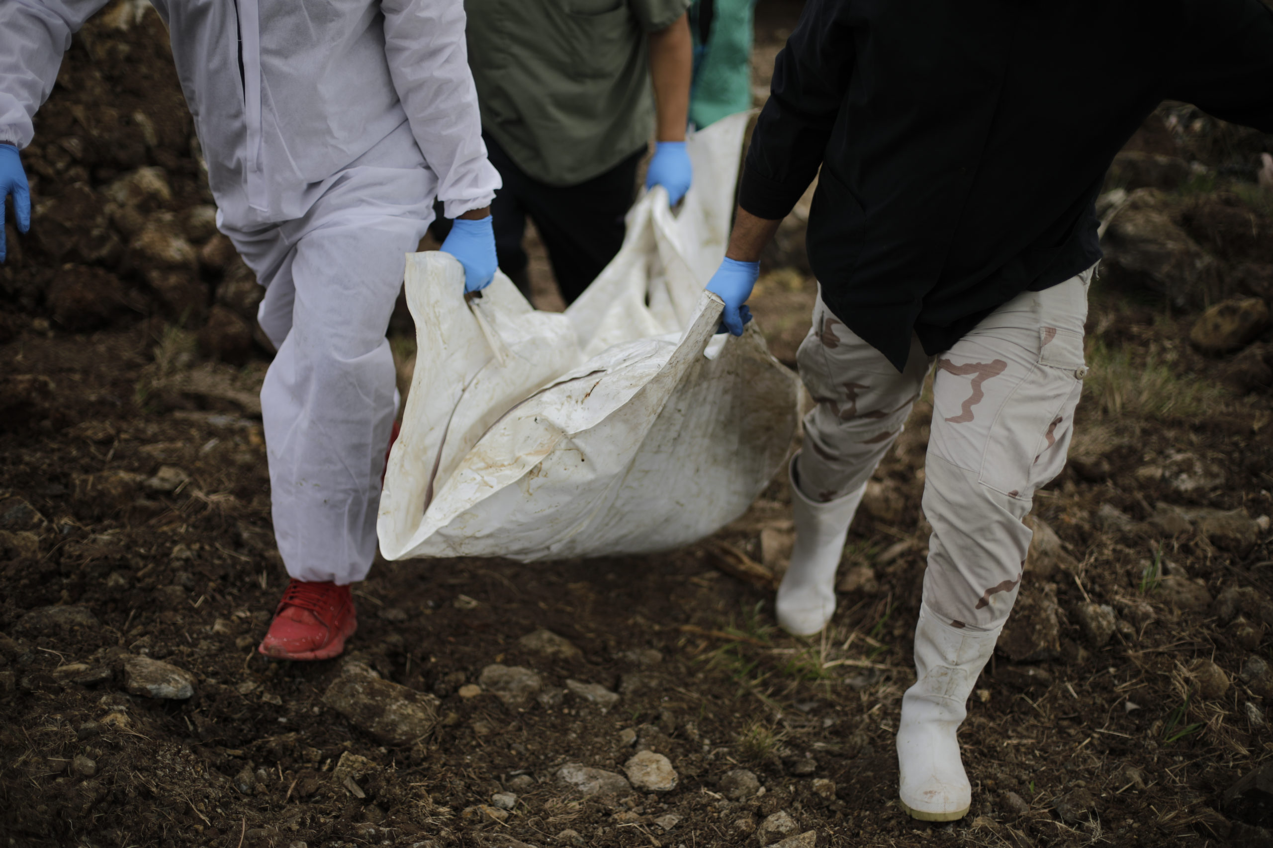 Miembros de medicina forense cargan una bolsa que contiene un cuerpo no reclamado. Foto CC/Jorge Cabrera