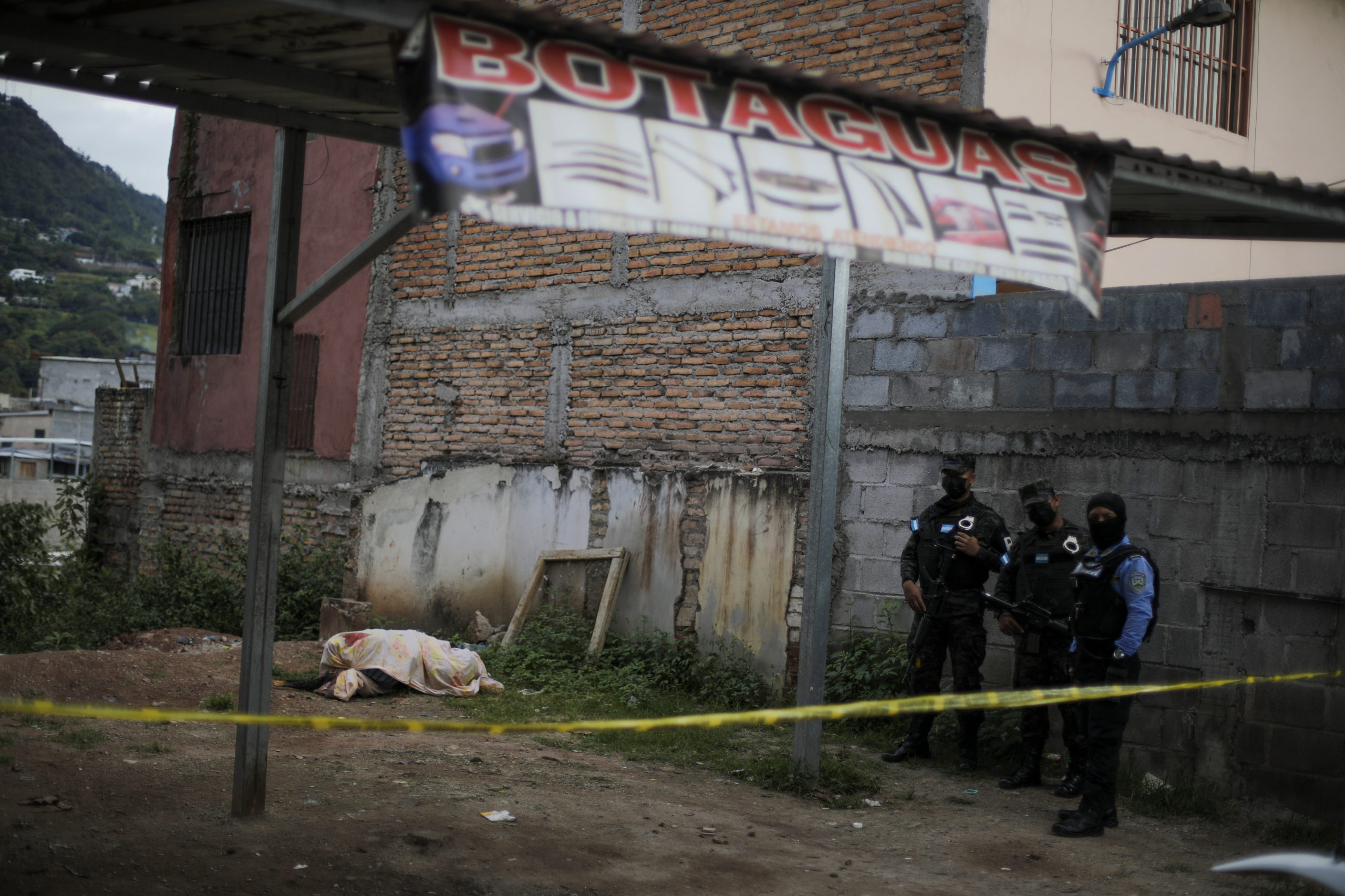 Miembros de la policía militar y policía nacional resguardan la escena del crimen donde fue encontrado el cuerpo de una persona encostalada. Foto CC/Jorge Cabrera