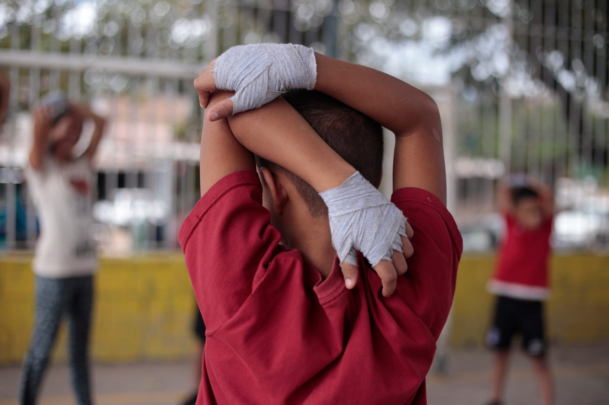 Ejercicios de estiramiento previo al entrenamiento de boxeo en las canchas de la colonia San Miguel de Tegucigalpa, Honduras Foto CC/Fernando Destephen.