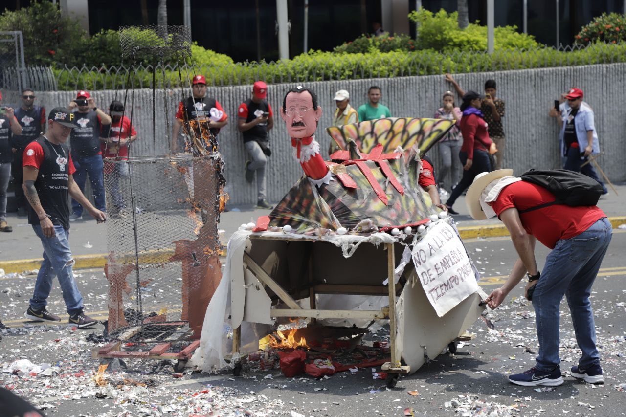Un monigote que representa a Mauricio Villeda, diputado que presentó proyecto de ley para empleo parcial, es quemado en el centro de San Pedro Sula durante la conmemoración del Día Internacional del Trabajador. Foto CC/Amilcar Izaguirre