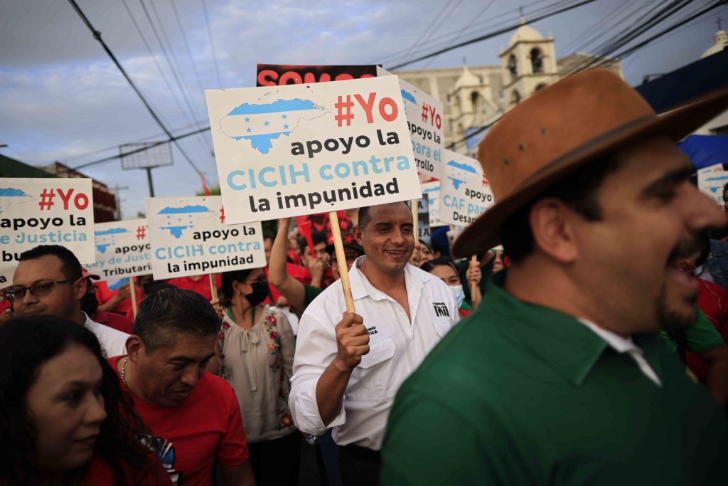 Miembros del Partido Libertad y Refundación cargan una pancarta exigiendo la llegada de la CICIH a Honduras, durante una marcha multitudinaria. Foto CC/Jorge Cabrera