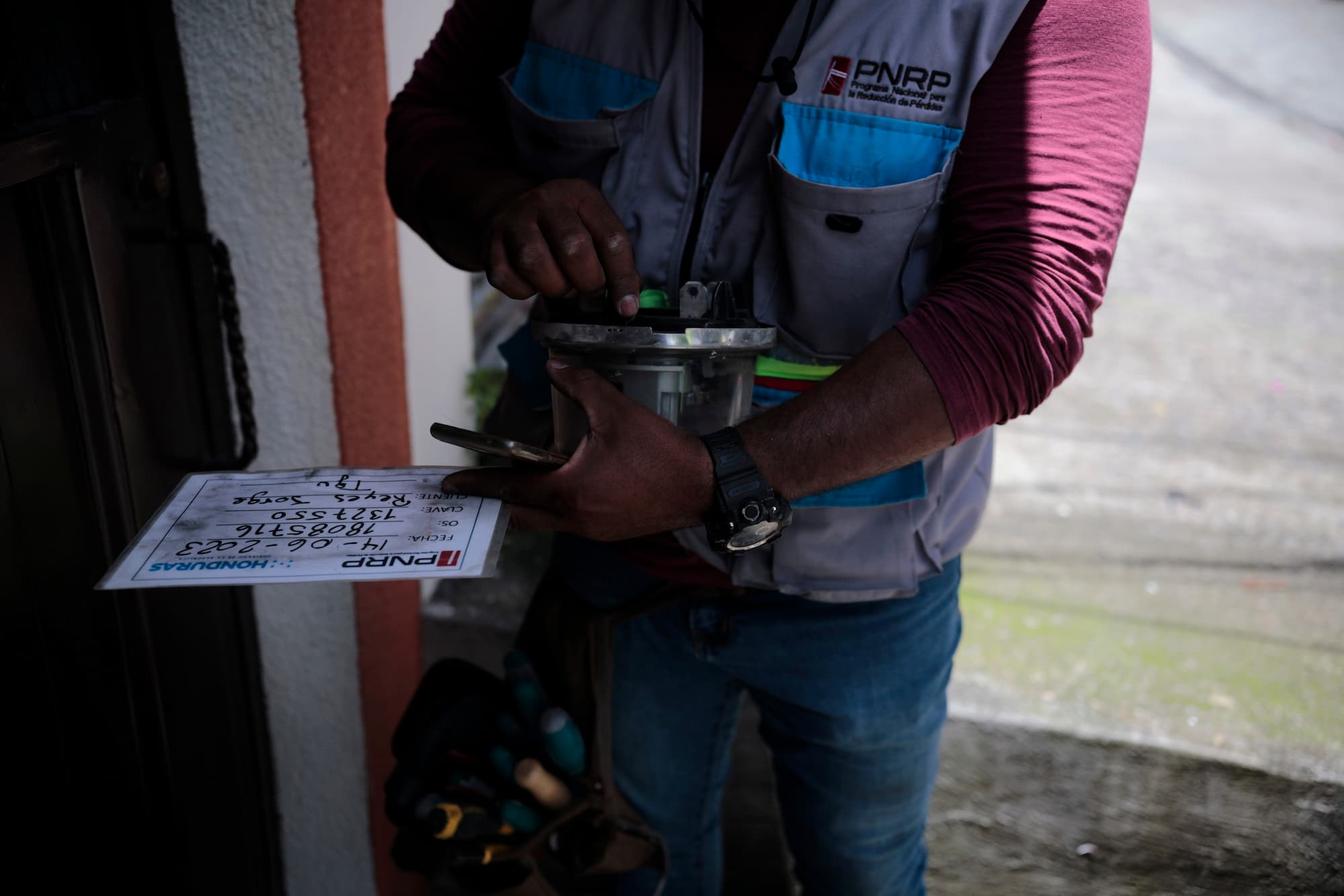 Un empleado del Programa Nacional para la Reducción de Pérdidas (PNRP) revisa un contador en Tegucigalpa. Foto CC/Fernando Destephen