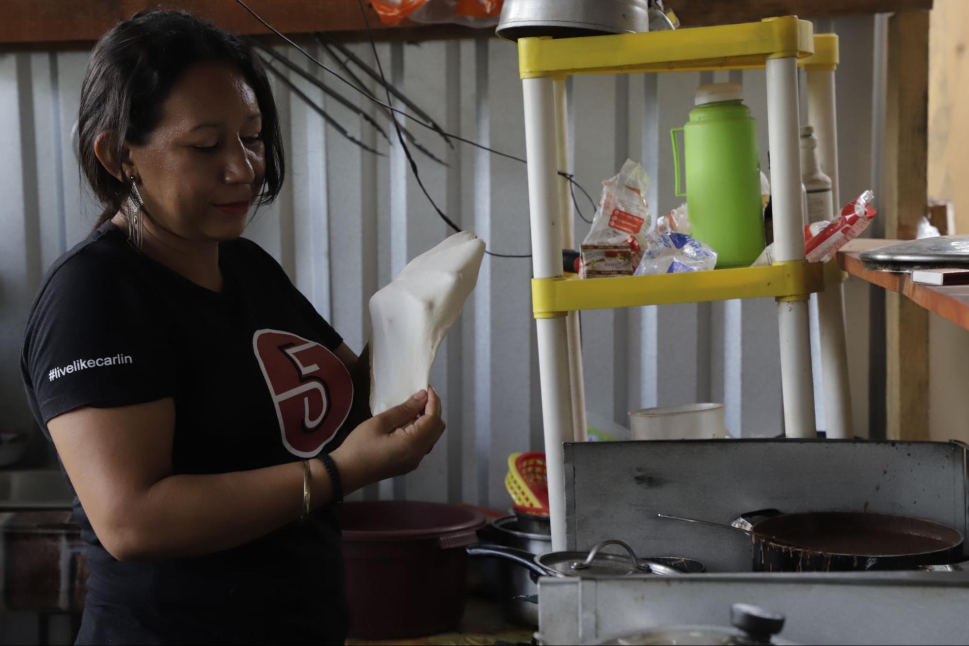 Sofía Ramírez prepara una tortilla de harina para hacer una baleada; hace tres años que fue despedida de Delta Apparel, ahora se gana la vida ayudando a un familiar en un pequeño negocio de comida. Fotos CC/Amílcar Izaguirre