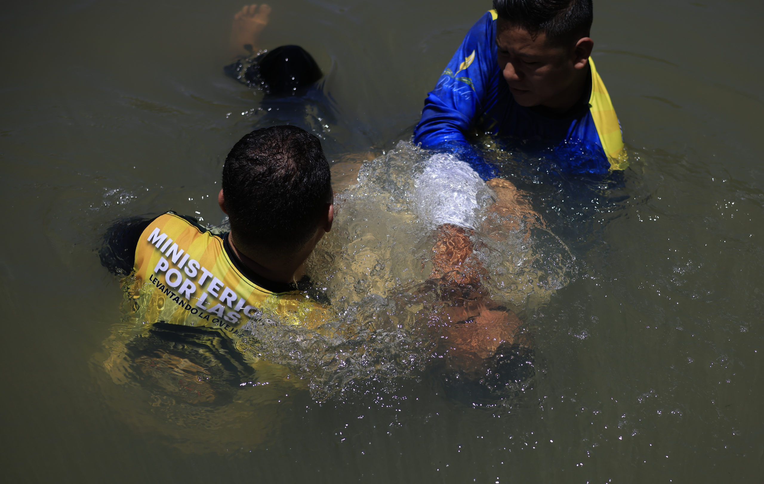 Pastores del Ministerio Amor por las Almas bautizan a un exmiembro de la pandilla MS-13 en el río de San Matías que es controlado por el Barrio 18. Foto CC/Jorge Cabrera