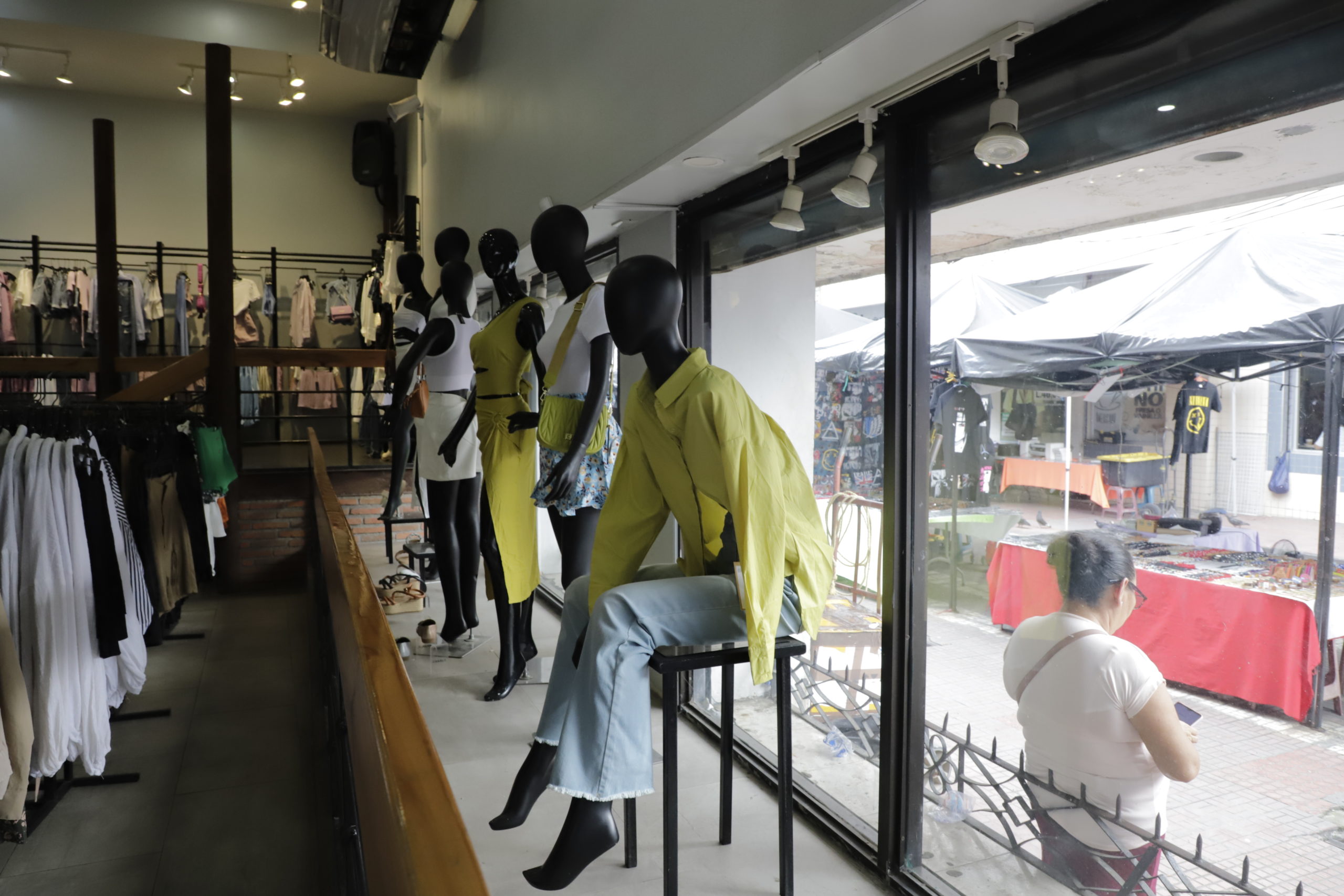 Una ventana de cristal divide los productos de un negocio formal y un negocio informal, ambos compiten por el espacio que queda entre los edificios, las aceras y las calles en el Centro de San Pedro Sula. Foto CC/Amilcar Izaguirre