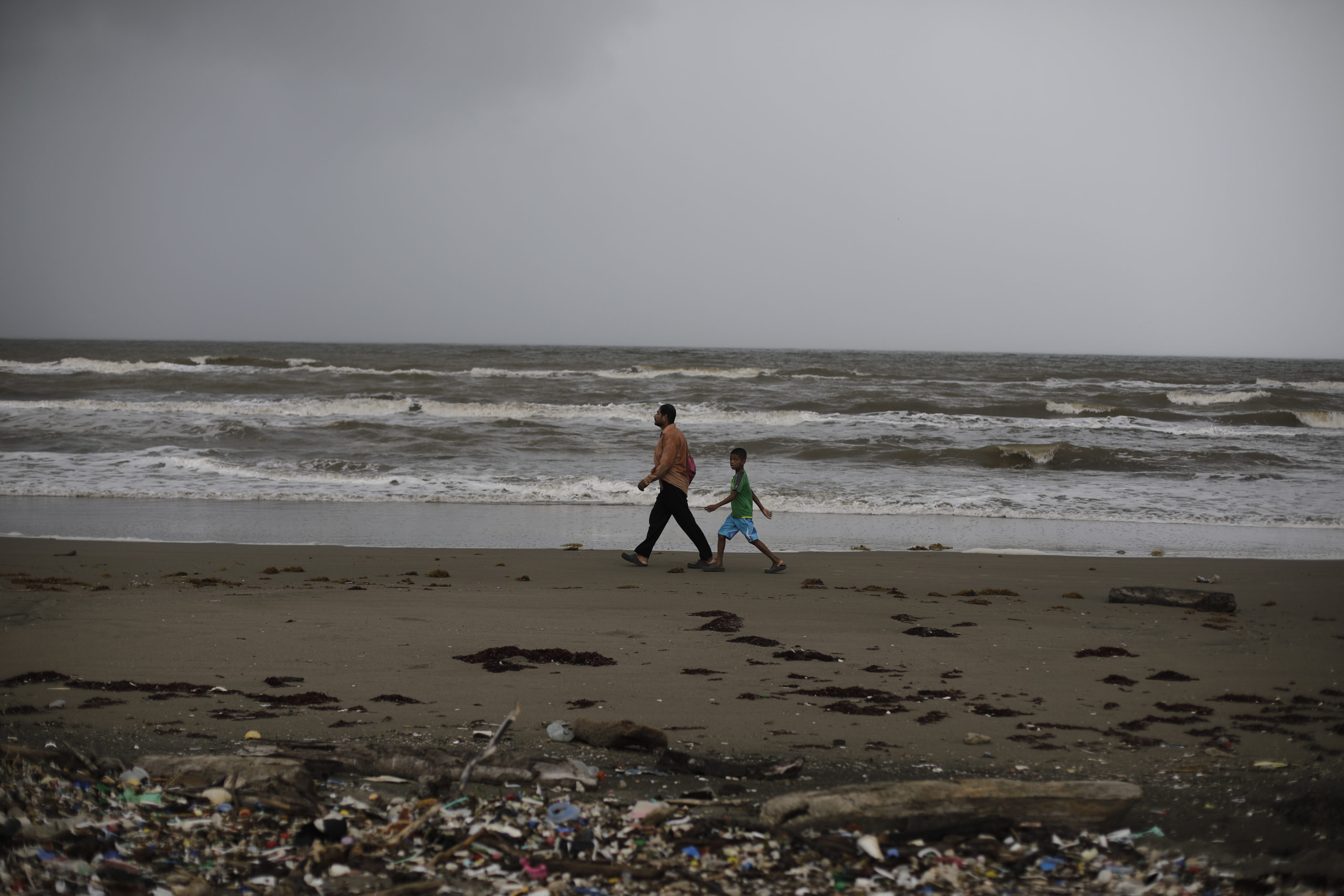 Un padre y su hijo recorren las costas de las playas caribeñas llenas de basura. Foto CC/Jorge Cabrera