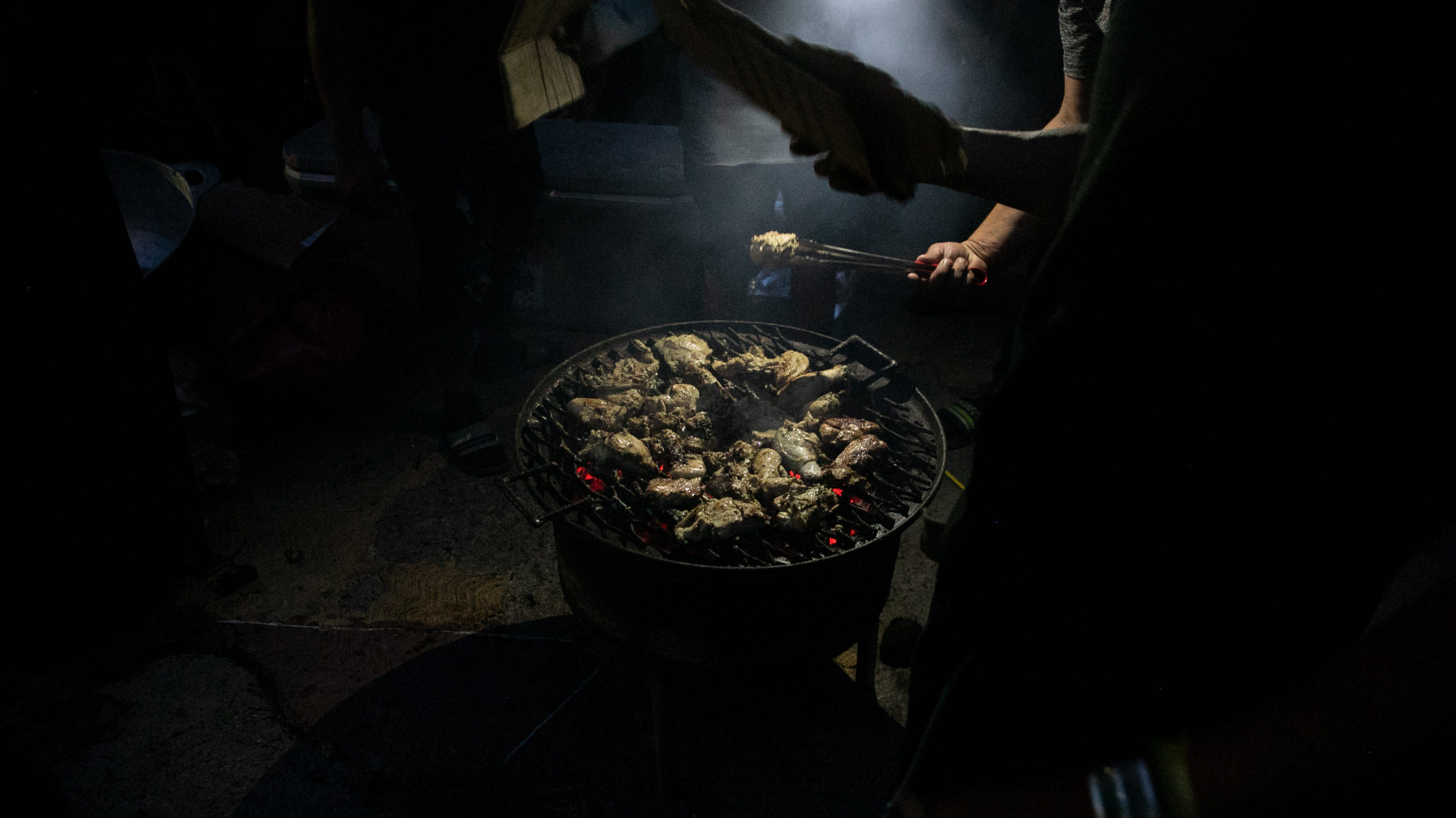 Campesinos preparan pollo asado en un anafre en los bajos del Congreso Nacional. Tegucigalpa, septiembre de 2024. Foto CC / Fernando Destephen.