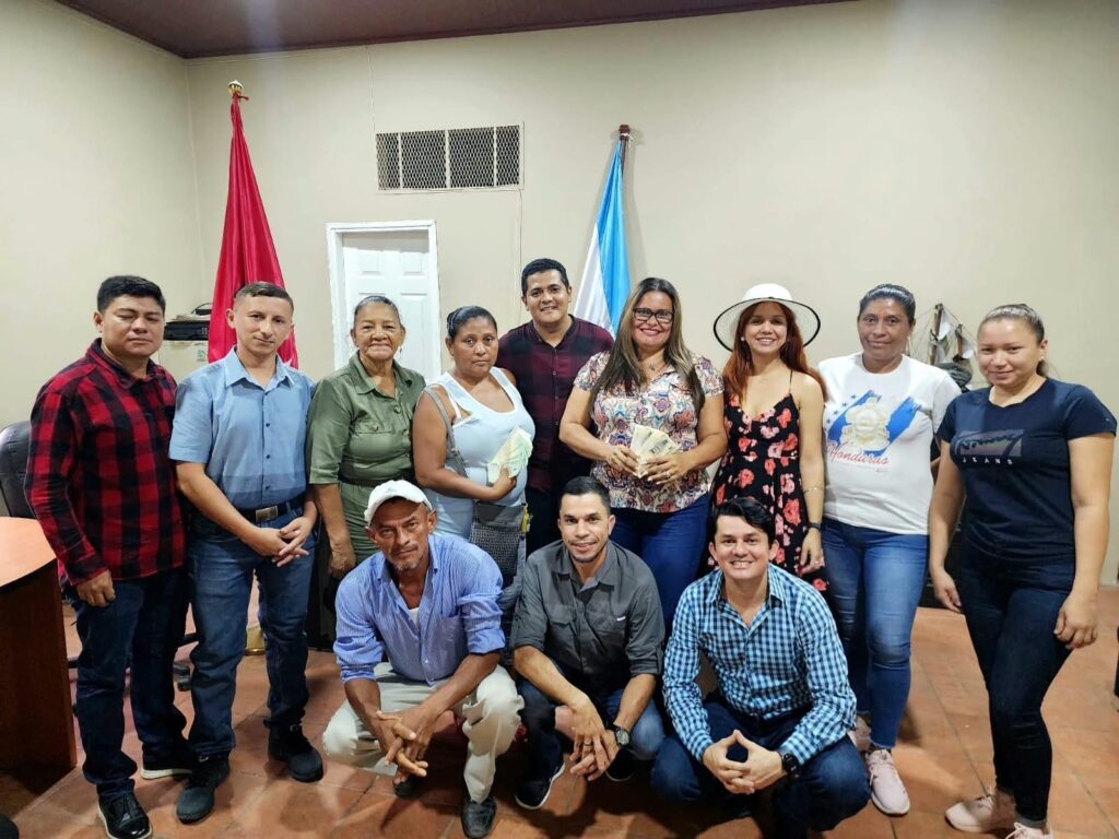 Fabricio Sandoval y Néstor Yanes, diputados del Partido Libre, entregan dinero en efectivo proveniente de las subvenciones a colectivos del Libre en el departamento de Valle, al sur de Honduras. Naveshna Rovelo, directora de Convivienda, precandidata a diputada suplente y esposa de Fabricio Sandoval, también acompañó la entrega. Foto: Cuenta Bancada Libre en X