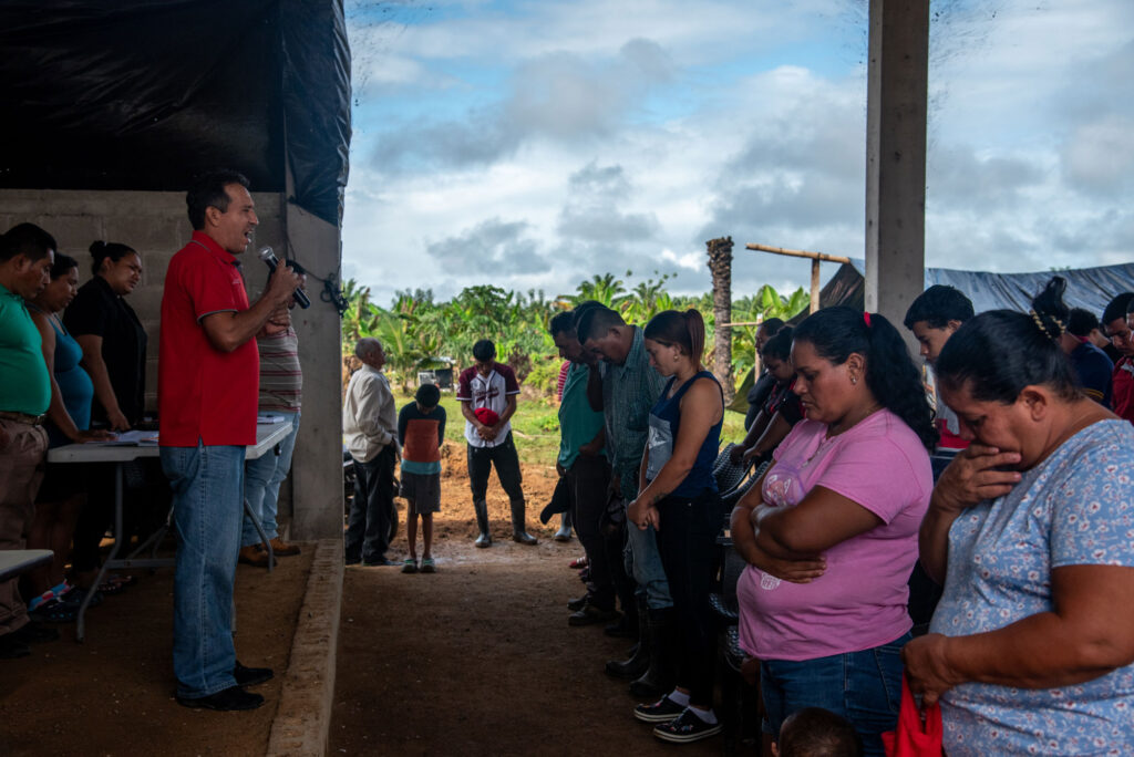 Miembros de la Plataforma Agraria se unen en oración junto a los campesinos atacados de la finca Tranvío. Foto de Seth Berry.