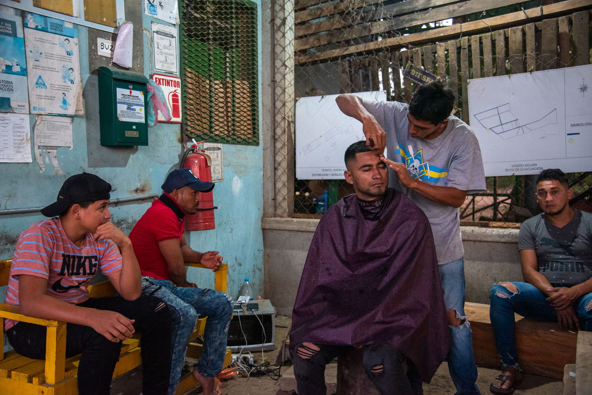 Campesinos de la finca Camarones preparan el almuerzo para los integrantes de la cooperativa días después de sufrir un desplazamiento forzado por parte de un grupo paramilitar, en diciembre de 2024. A la derecha, un joven se corta el pelo en la cooperativa La Chile.
